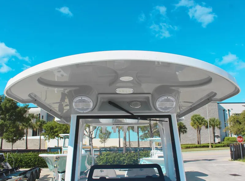 Slide: The Image of 2023 Seapro 259 boat with T-top and speakers, parked outdoors under blue sky. - 20