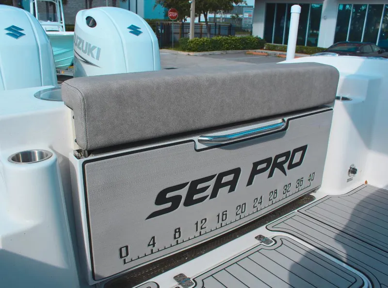 Slide: The Image of 2023 Seapro 259 boat with Suzuki engines, featuring a cushioned seat and storage compartment. - 8