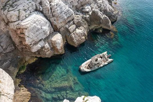 Slide: The Image of Arksen 8 yacht in clear blue water near rocky cliffs, 2025 model. - 6