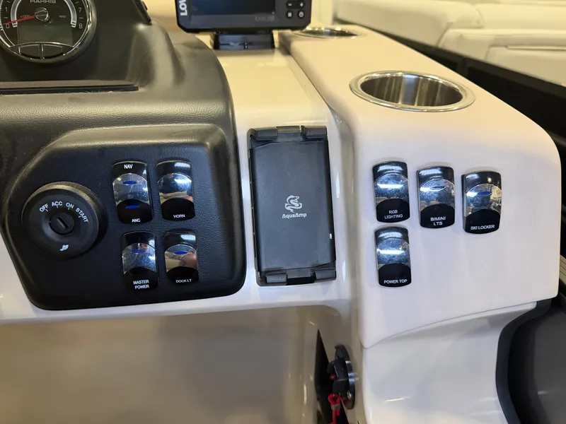 Slide: The Image of Dashboard of a Harris Cruiser 250 with switches and a cup holder. - 16