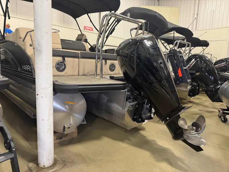 Slide: The Image of A 2025 Harris Cruiser 250 pontoon boat with a powerful outboard motor in a showroom. - 40