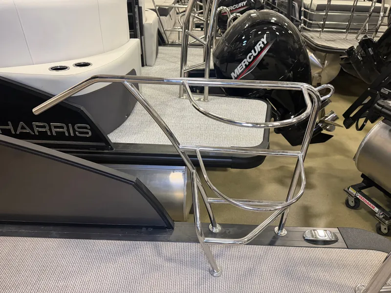 Slide: The Image of A 2025 Harris Cruiser 250 with a stainless steel railing and a Mercury engine in the background. - 35