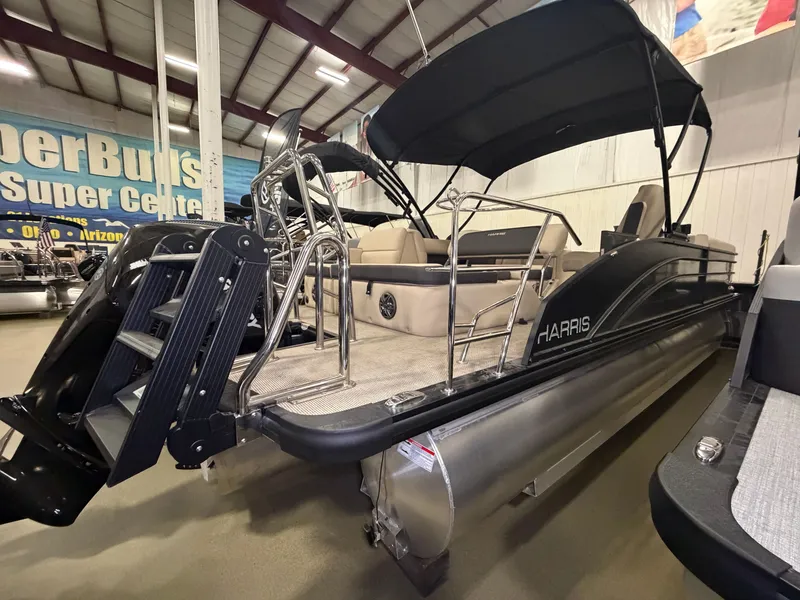 Slide: The Image of The image shows a 2025 Harris Cruiser 250 pontoon boat in a showroom. - 42
