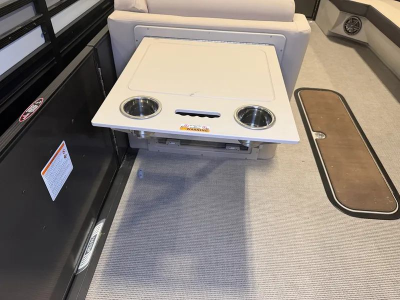 Slide: The Image of A foldable table with cup holders on a boat with carpeted flooring and seating bench. - 28