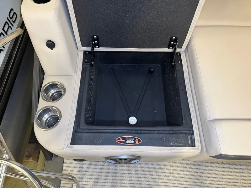 Slide: The Image of An open storage compartment in a 2025 Harris Cruiser 250 with cup holders beside it. - 37
