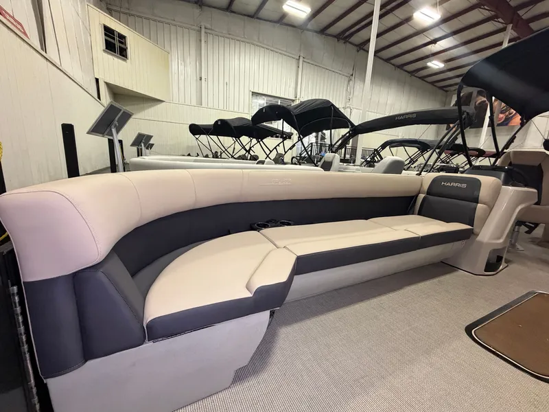Slide: The Image of Interior of a 2025 Harris Cruiser 250 with sleek upholstery in a warehouse setting. - 2