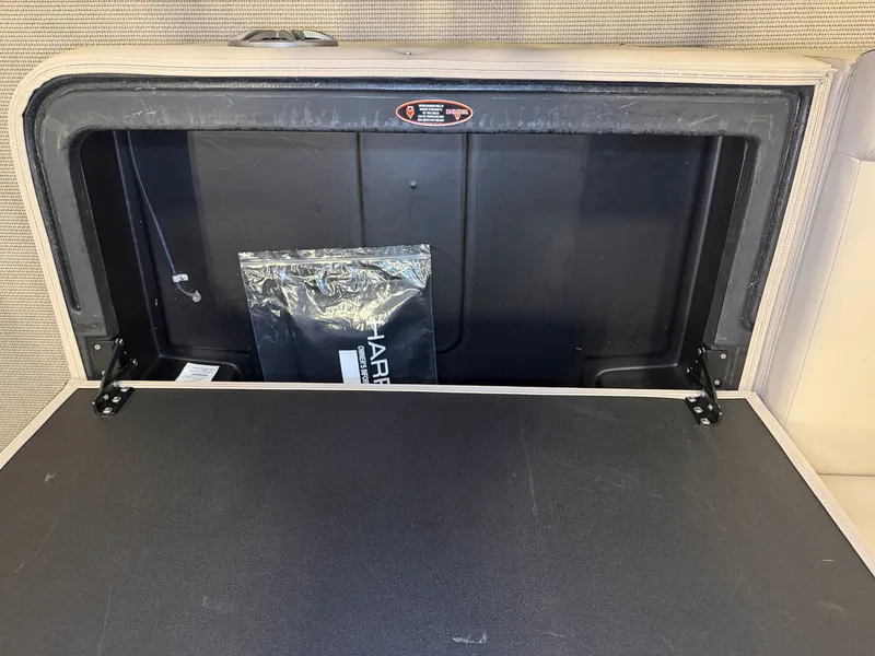 Slide: The Image of Storage compartment in the 2025 Harris Cruiser 250 with a black cover. - 38