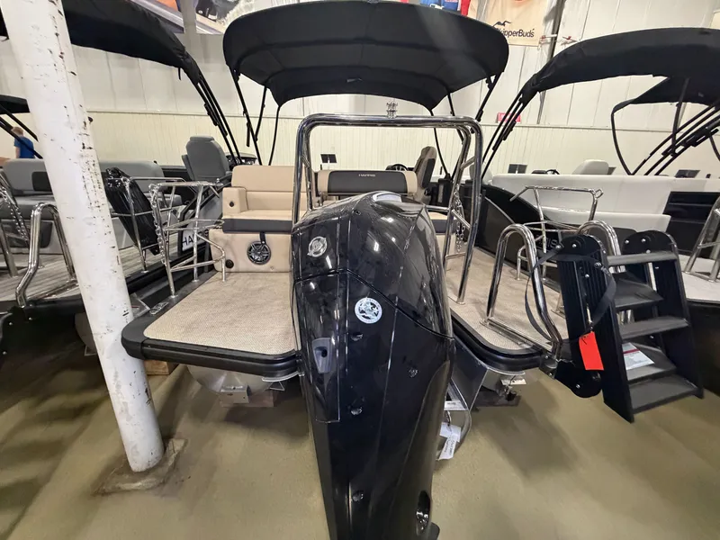 Slide: The Image of The image shows a 2025 Harris Cruiser 250 pontoon boat in a showroom. - 41