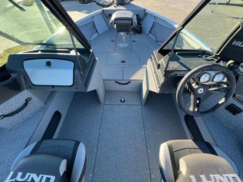 Slide: The Image of 2024 Lund 2075 Alaskan Sport boat interior with steering wheel and seating. - 10