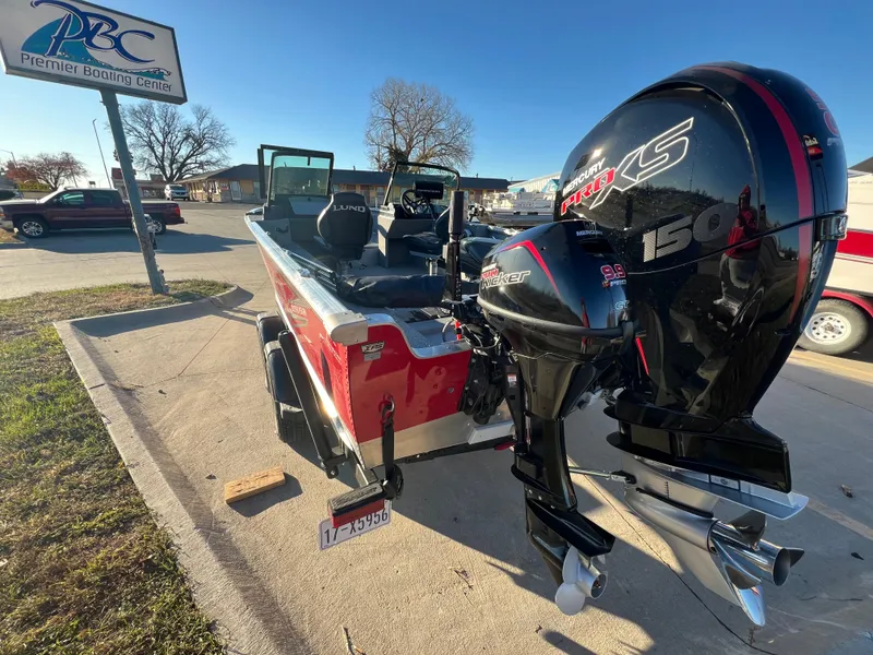 Slide: The Image of 2024 Lund 2075 Alaskan Sport boat with powerful outboard motor at a dealership. - 4