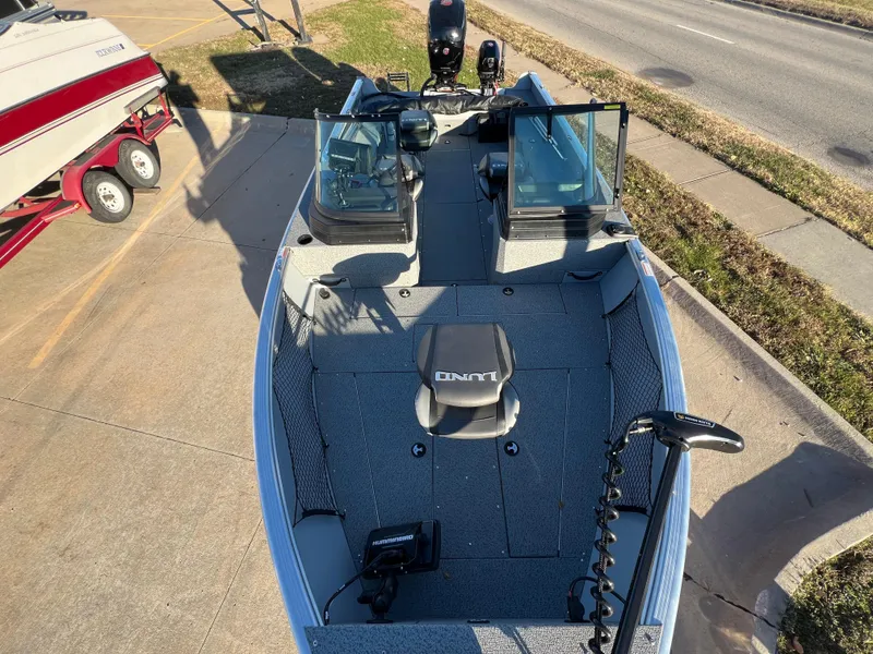 Slide: The Image of 2024 Lund 2075 Alaskan Sport boat, dual consoles, parked on pavement. - 6