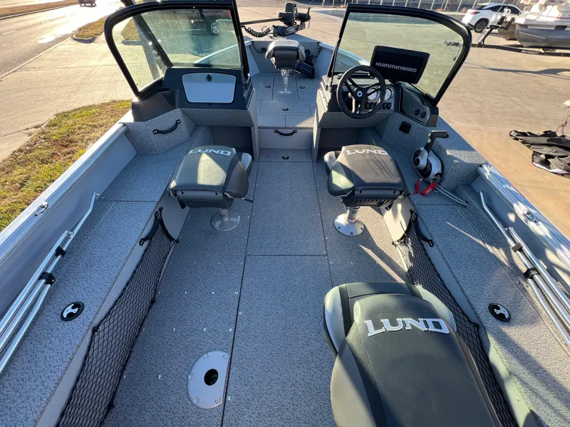 Slide: The Image of 2024 Lund 2075 Alaskan Sport boat interior with seating and steering console. - 8