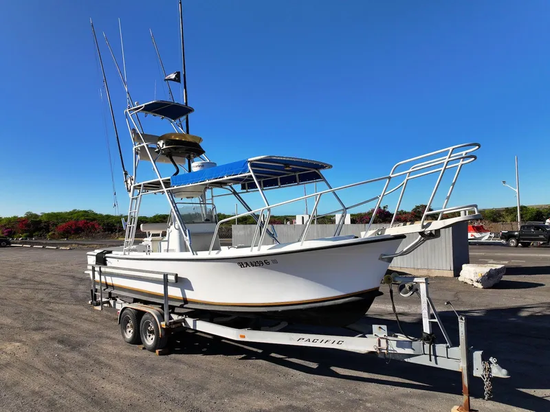 Slide: The Image of 1997 Shamrock 260 Open boat on trailer, parked outdoors under clear blue sky. - 10