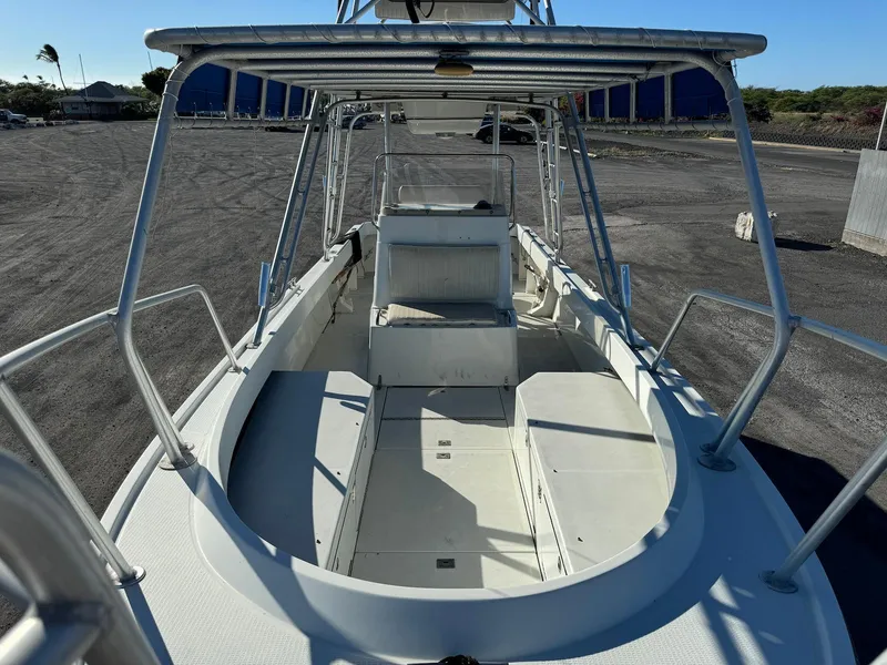 Slide: The Image of 1997 Shamrock 260 Open boat, spacious deck, sturdy railings, parked on gravel lot. - 20