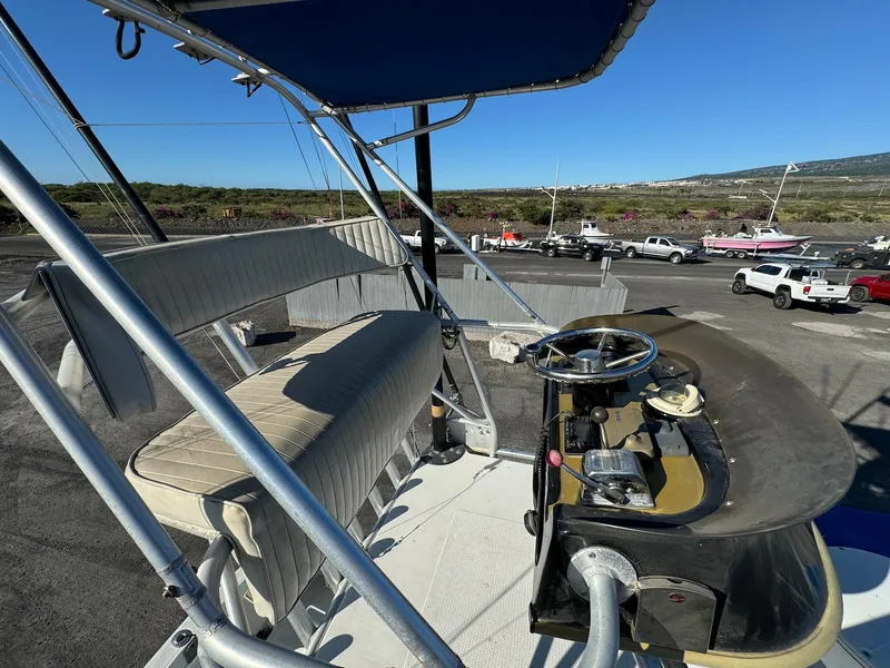 Slide: The Image of 1997 Shamrock 260 Open boat helm with seating, docked in a marina under clear skies. - 23