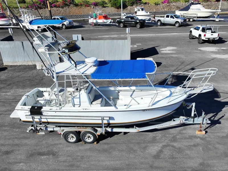 Slide: The Image of 1997 Shamrock 260 Open boat with blue canopy on a trailer in a parking lot. - 7