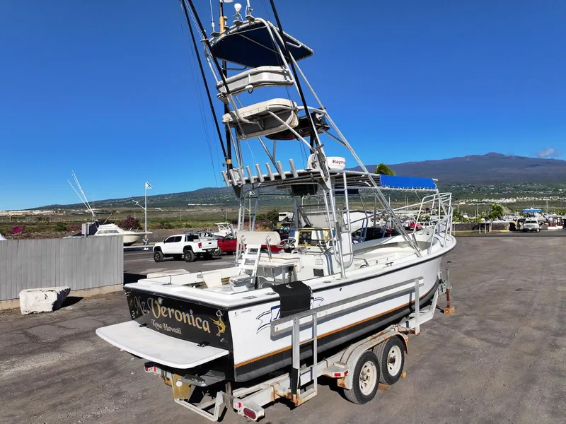 Slide: The Image of 1997 Shamrock 260 Open boat on trailer, clear sky, mountain backdrop. - 9