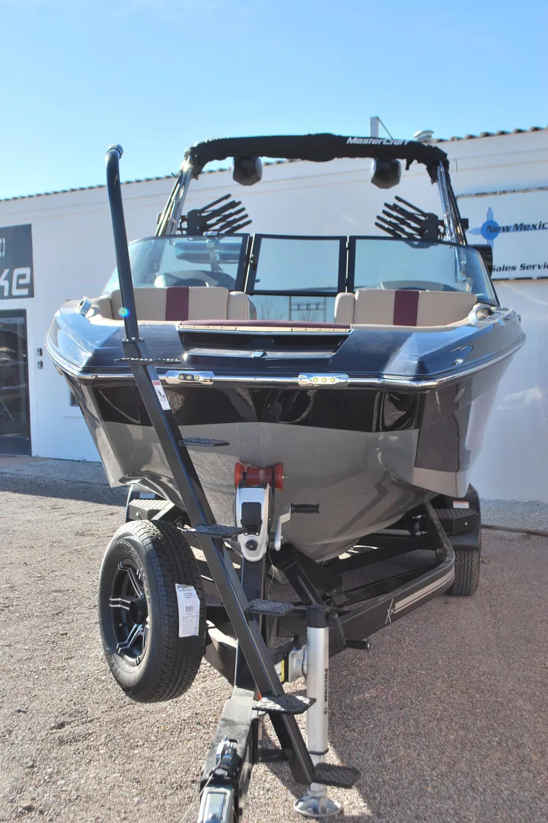 Slide: The Image of 2023 MasterCraft X24 boat on trailer, front view, in outdoor setting. - 4