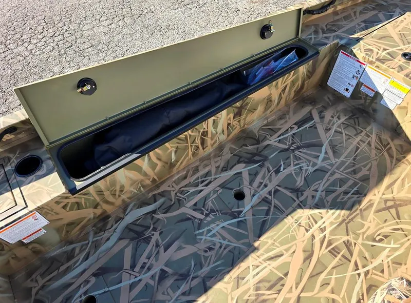 Slide: The Image of Lowe Outlet 20 boat interior, 2025 model, featuring camo design and storage compartment. - 10