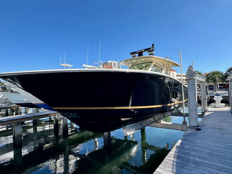 Slide: The Image of 2019 Scout 380 LXF boat docked at marina under clear blue sky. - 1
