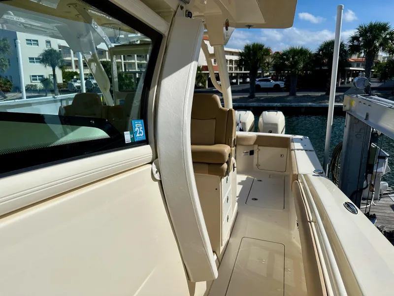Slide: The Image of 2019 Scout 380 LXF boat docked, showcasing sleek design and luxurious seating. - 13