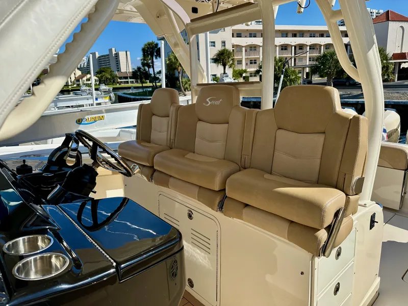 Slide: The Image of 2019 Scout 380 LXF boat interior with beige seating and steering console. - 14