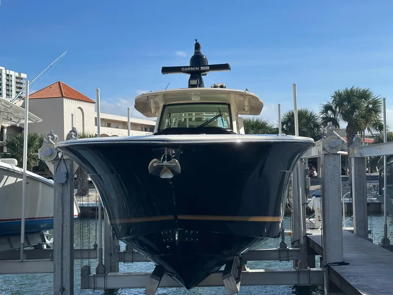 Slide: The Image of 2019 Scout 380 LXF boat docked at marina under clear blue sky. - 2