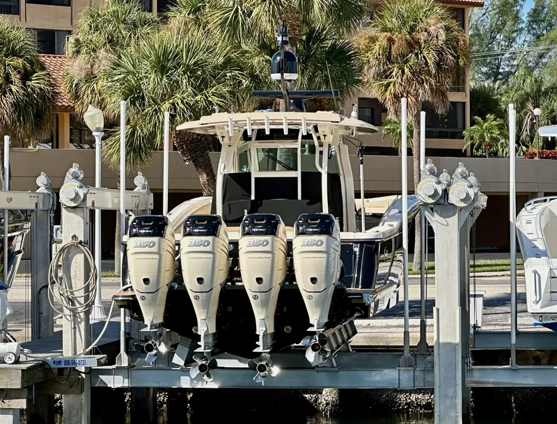 Slide: The Image of 2019 Scout 380 LXF boat with four powerful engines docked near palm trees. - 22