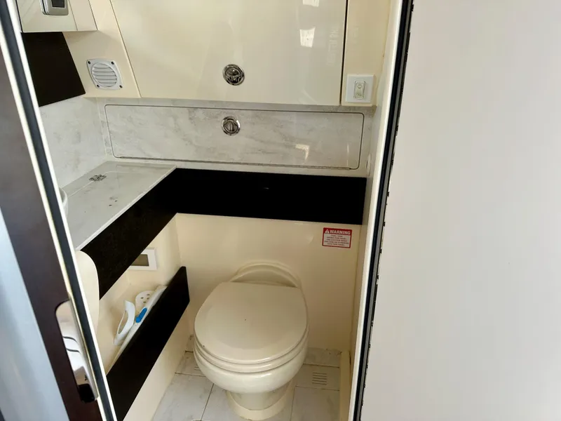 Slide: The Image of 2019 Scout 380 LXF boat bathroom with toilet and storage cabinets. - 24