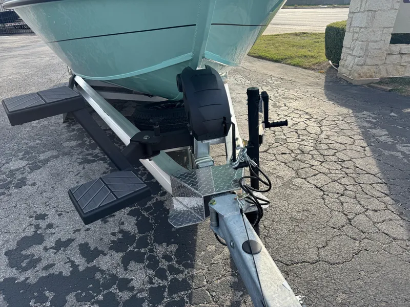 Slide: The Image of 2025 Vexus ACX 2210 boat trailer with teal hull on cracked pavement. - 6