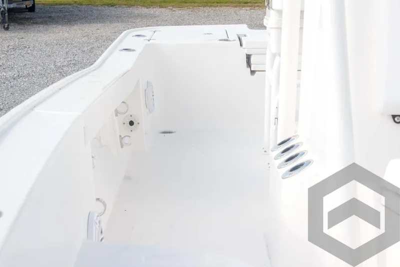Slide: The Image of 2025 Caymas 26 HB boat interior, featuring spacious white deck and rod holders. - 34