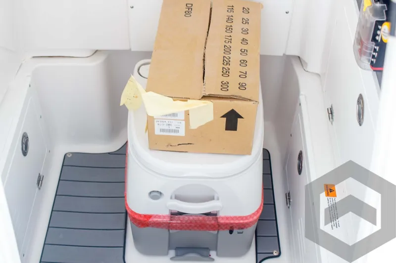 Slide: The Image of Caymas 26 HB 2025 boat storage area with cooler and cardboard box. - 40