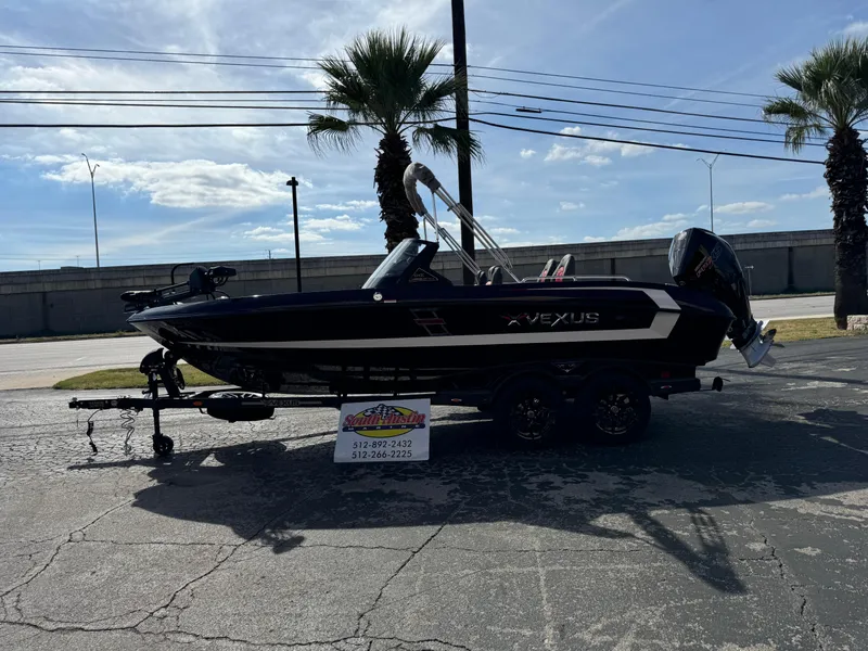 Slide: The Image of 2025 Vexus DVX20S boat on trailer, parked outdoors with palm trees. - 1