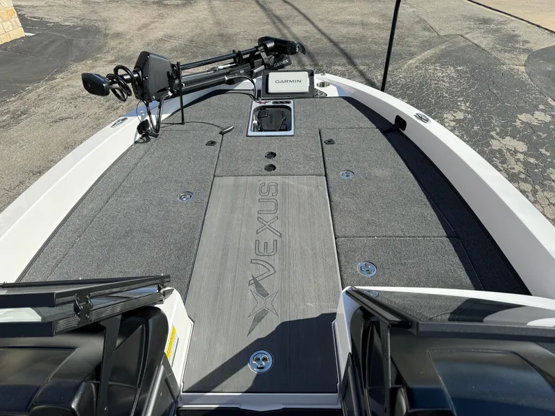 Slide: The Image of 2025 Vexus DVX20S boat deck with Garmin equipment, gray carpeting, and storage compartments. - 12