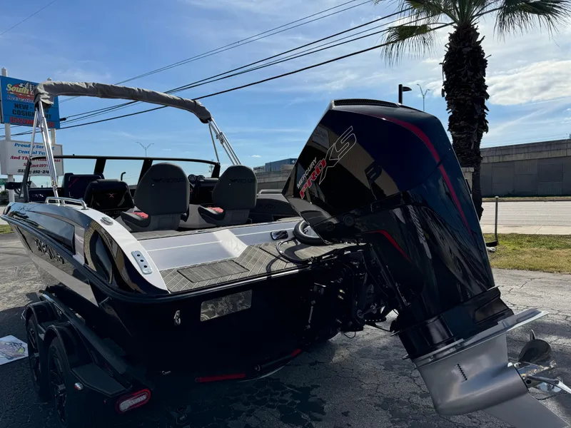 Slide: The Image of 2025 Vexus DVX20S boat with powerful outboard motor, parked outdoors. - 2