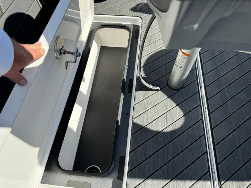 Slide: The Image of Vexus DVX20S 2025 boat storage compartment with open lid on deck. - 30