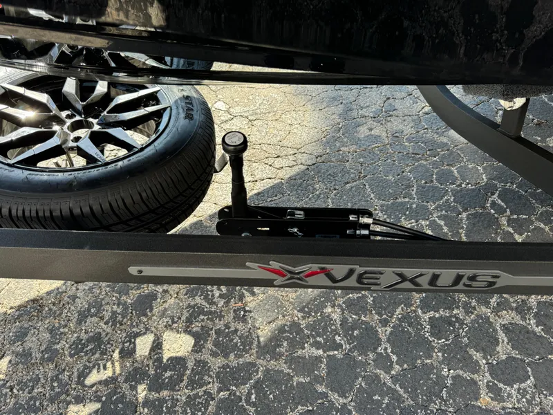Slide: The Image of 2025 Vexus DVX20S trailer with spare tire on textured pavement. - 40