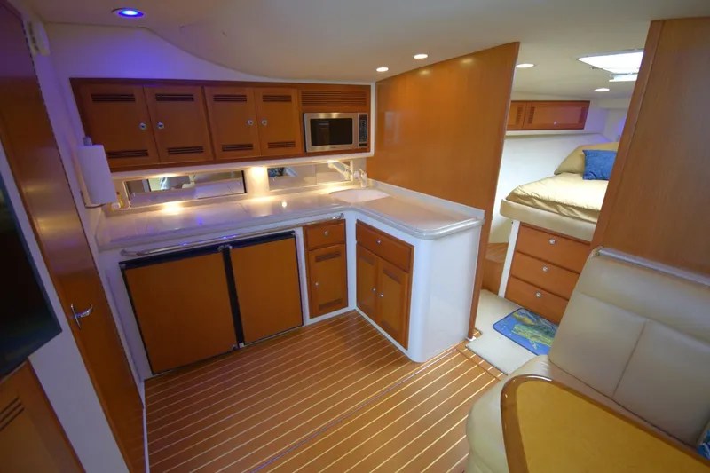 Slide: The Image of 2004 Cabo 40 Express yacht interior with kitchenette and cozy sleeping area. - 13