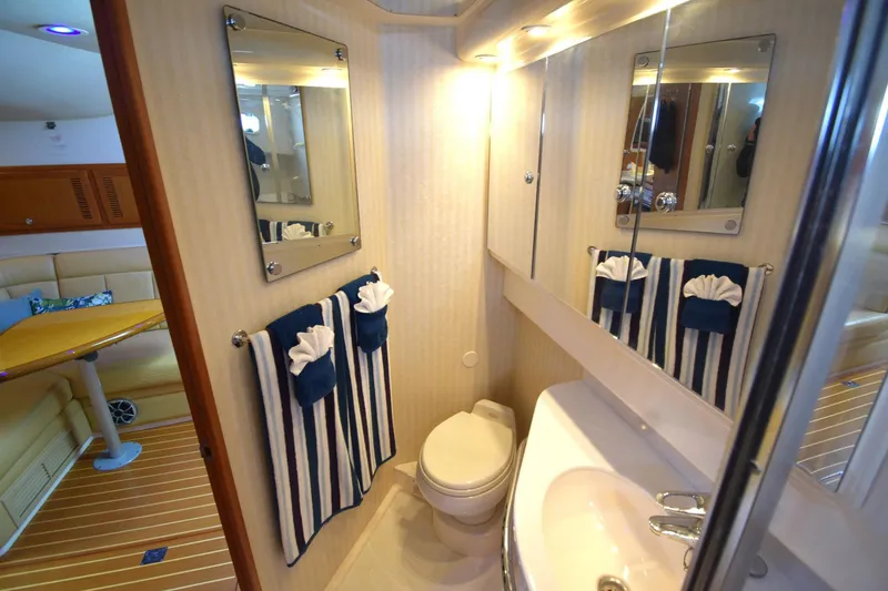 Slide: The Image of Luxurious 2004 Cabo 40 Express yacht bathroom with elegant fixtures and striped towels. - 14