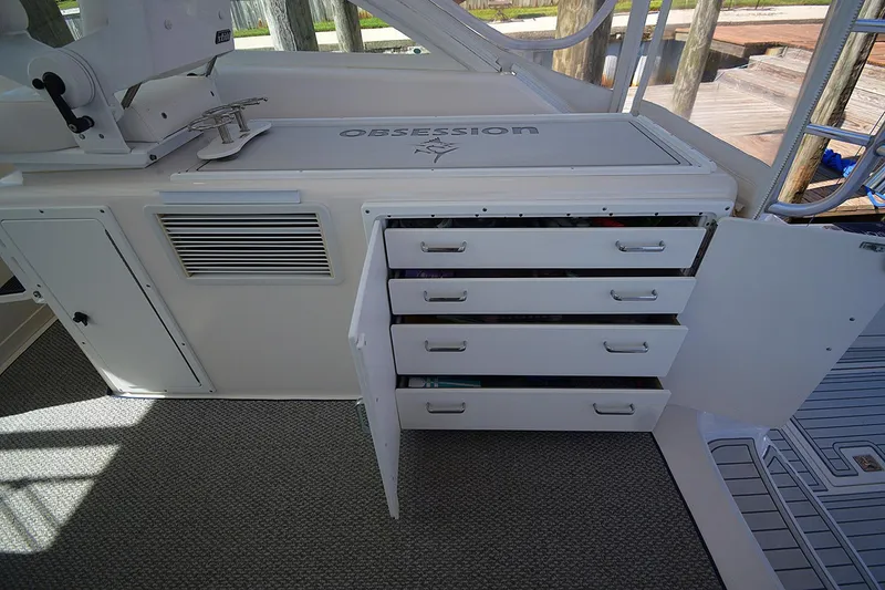 Slide: The Image of 2004 Cabo 40 Express boat interior with open storage drawers and "Obsession" branding. - 5