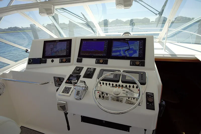 Slide: The Image of Helm of 2004 Cabo 40 Express yacht with navigation screens and controls. - 7