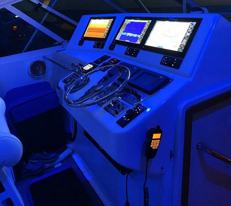 Slide: The Image of Cabo 40 Express 2004 boat helm with illuminated navigation screens and controls. - 8