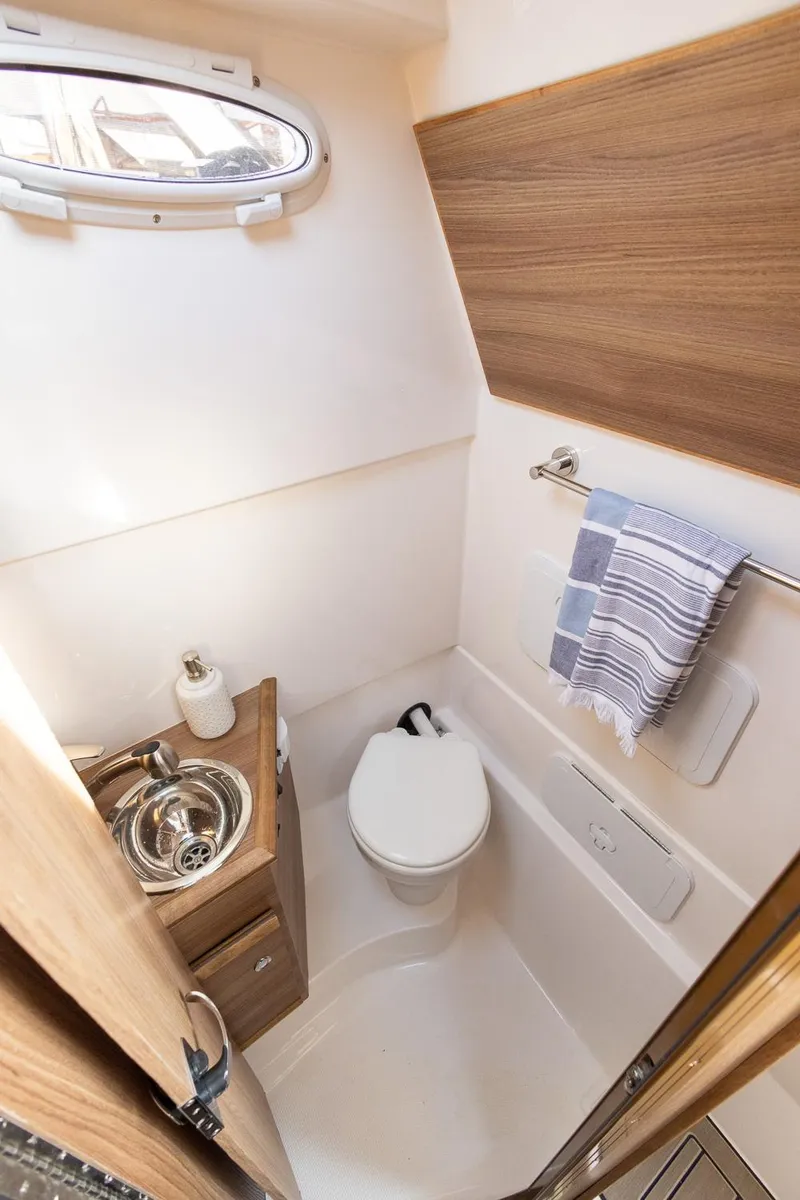 Slide: The Image of Compact bathroom in 2025 Solara S-310 CW boat with modern fixtures and wood accents. - 26