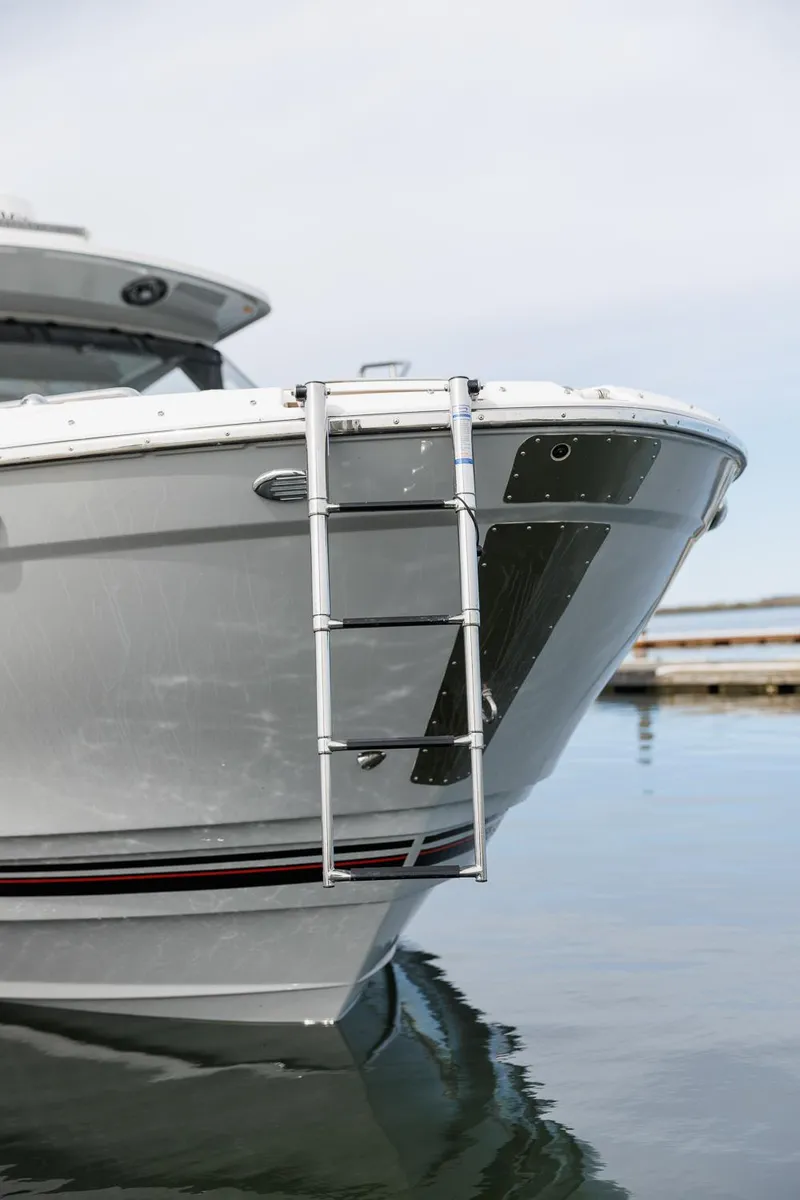 Slide: The Image of Solara S-310 CW 2025 boat bow with ladder on calm water. - 36