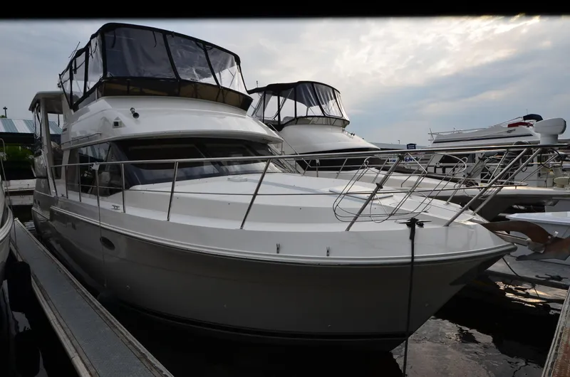The Image of 2001 Carver 406 yacht docked at marina under cloudy sky. - 0