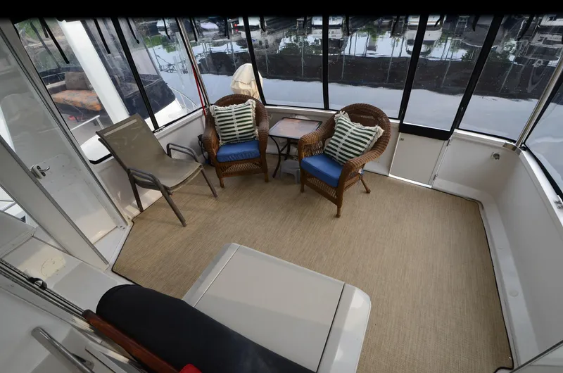 Slide: The Image of Spacious 2001 Carver 406 yacht interior with wicker chairs and marina view. - 10