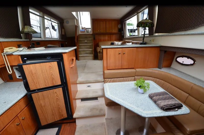 Slide: The Image of Interior of 2001 Carver 406 yacht with wood cabinetry and cozy seating area. - 18