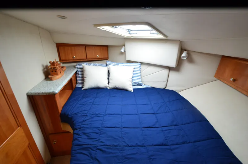 Slide: The Image of Cozy cabin interior of 2001 Carver 406 yacht with blue bedding and wooden cabinets. - 20