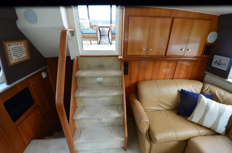 Slide: The Image of Interior of 2001 Carver 406 yacht with stairs, leather sofa, and wooden cabinets. - 23
