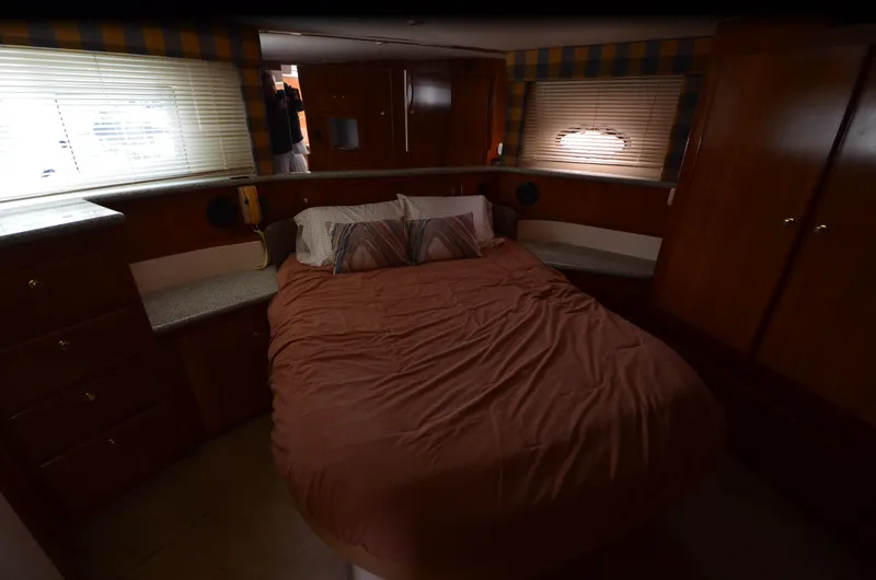 Slide: The Image of Cozy bedroom interior of 2001 Carver 406 yacht with wood cabinetry and soft lighting. - 24